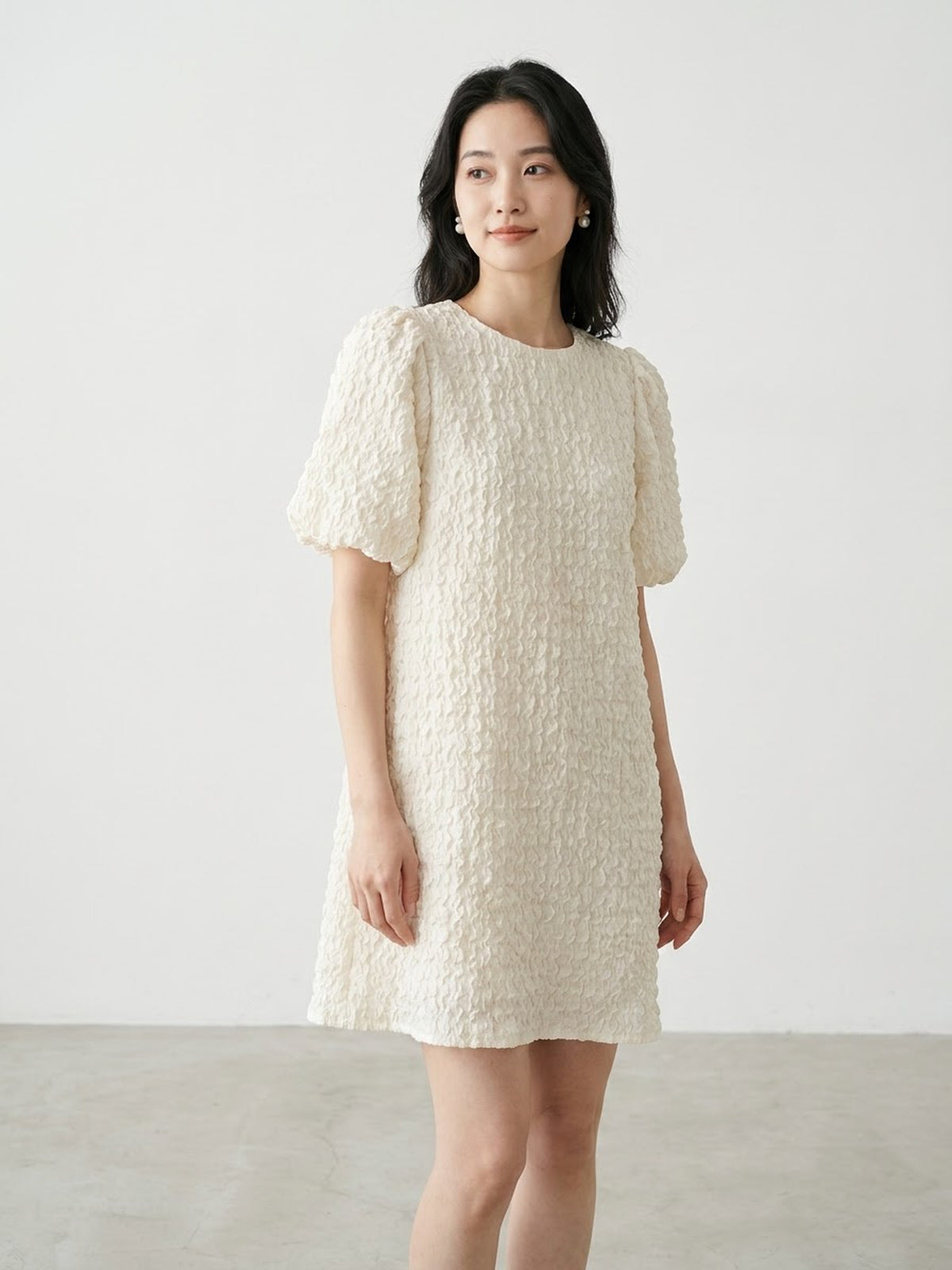 Two women wearing textured short-sleeve mini dresses in black and white