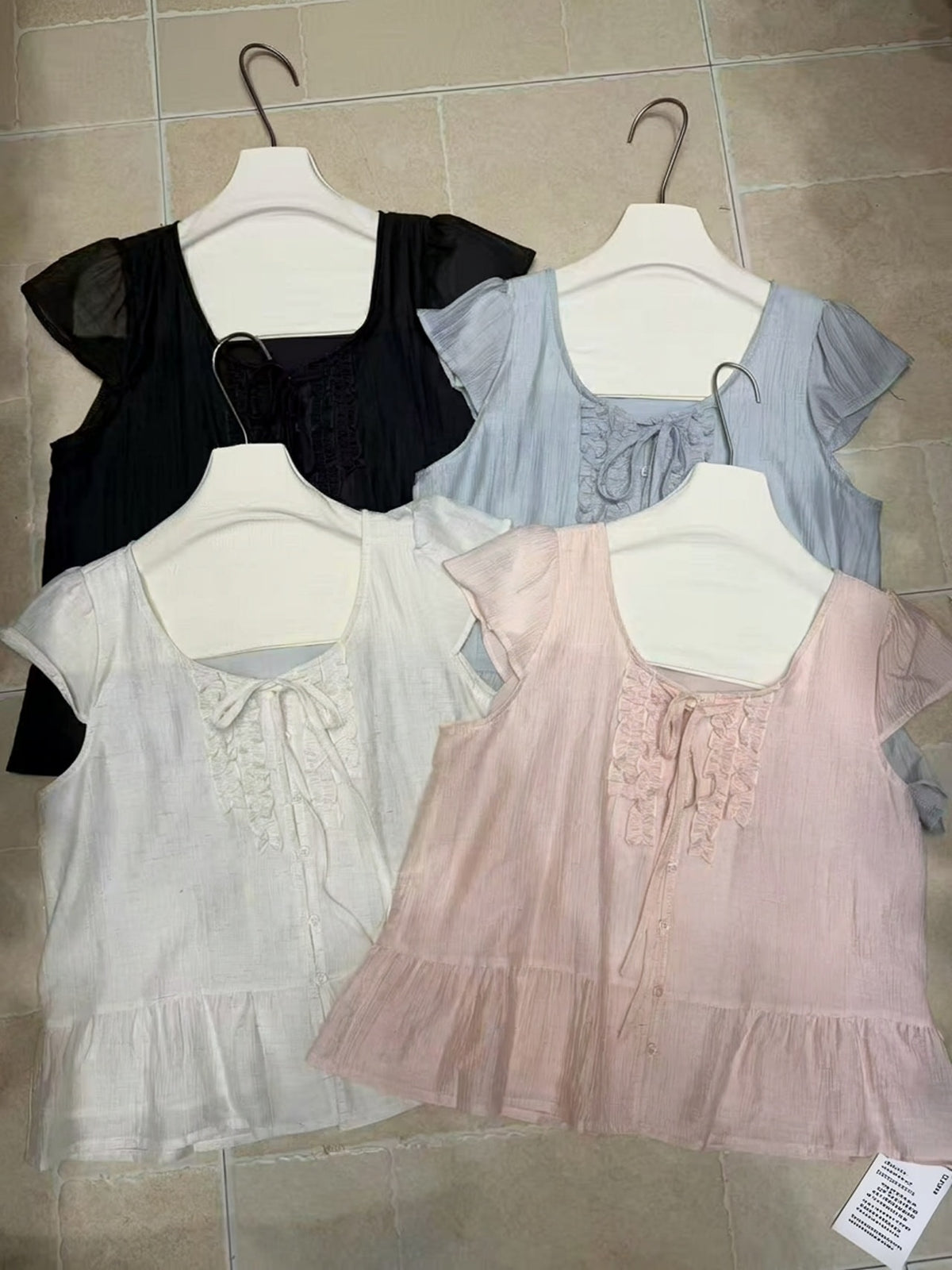 Four ruffled lace-up blouses in coffee, blue, apricot, and pink