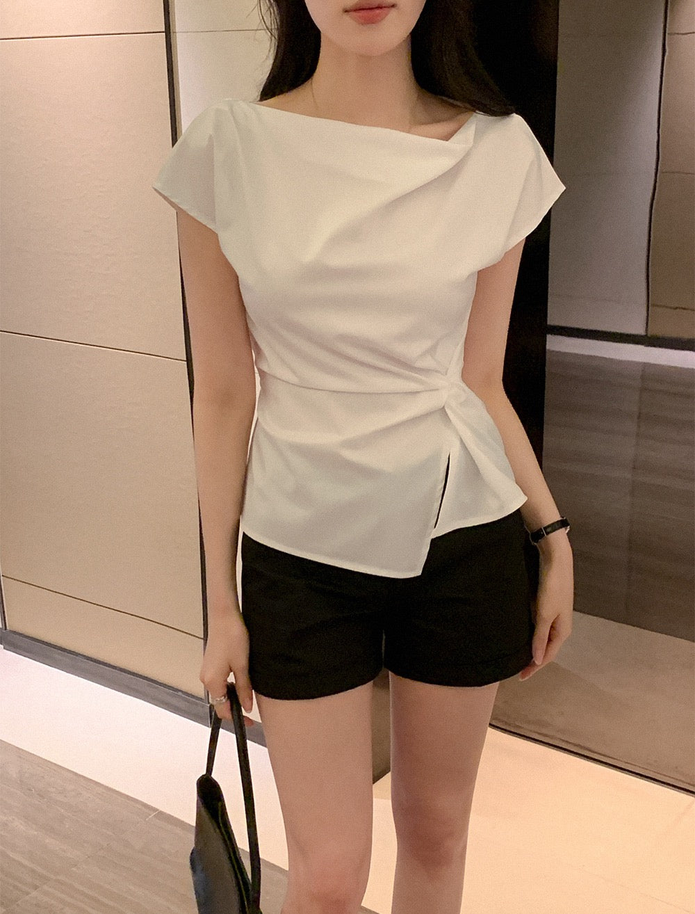 Close-up of a white cowl neck top with waist knot detail.