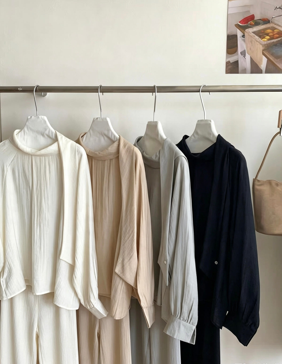Four matching sets of two-way tie blouses and bottoms hanging on a rack.