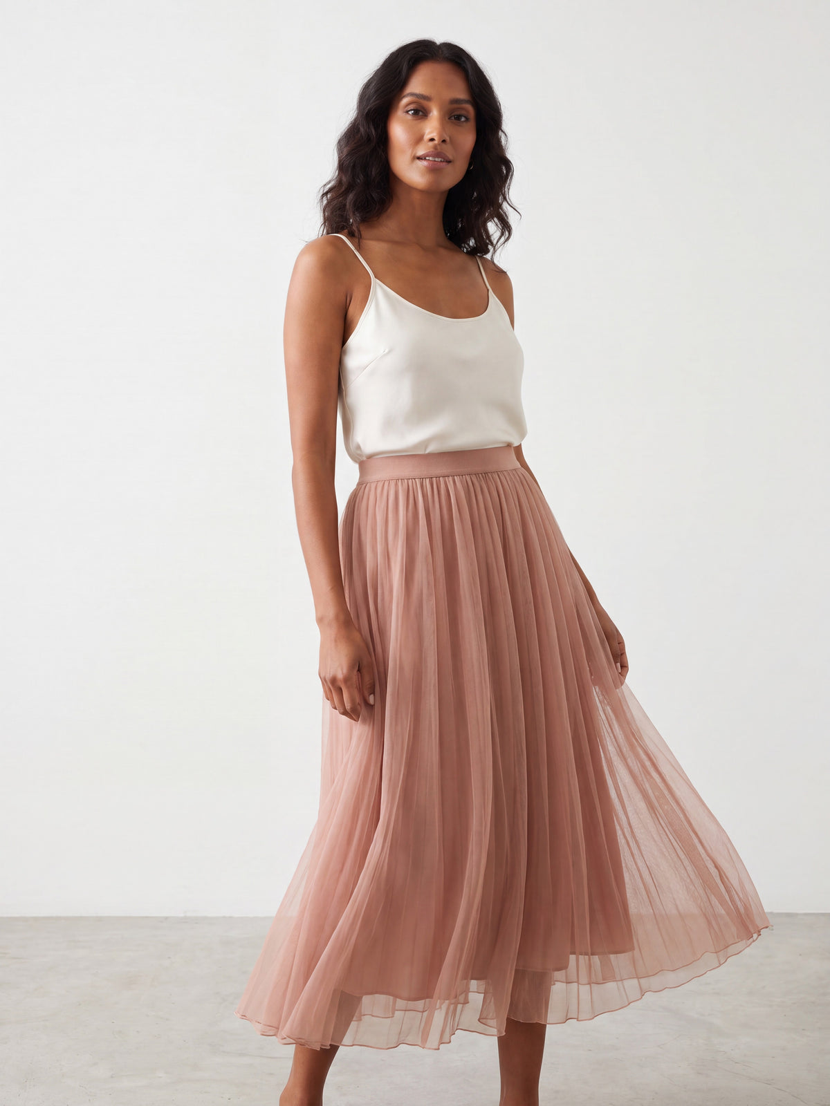 Dark pink and apricot mesh skirts hanging next to a white top