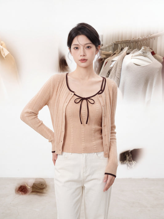 Woman modeling orange-pink ribbed knit cardigan set with a bag