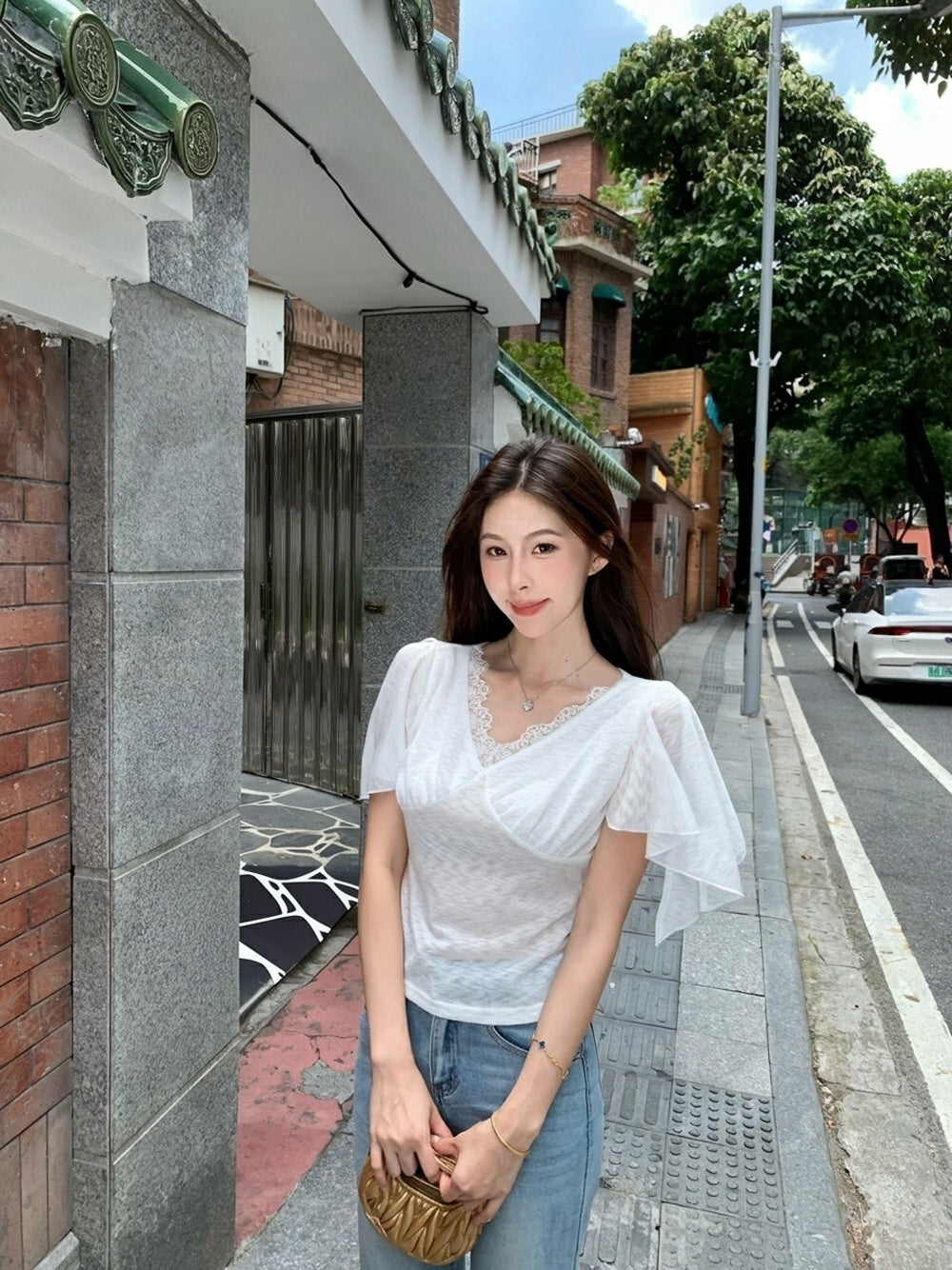 Woman wearing a white lace v-neck flutter sleeve top