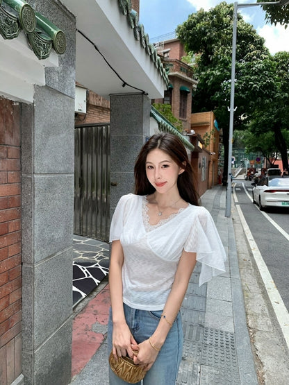 Woman wearing a white lace v-neck flutter sleeve top