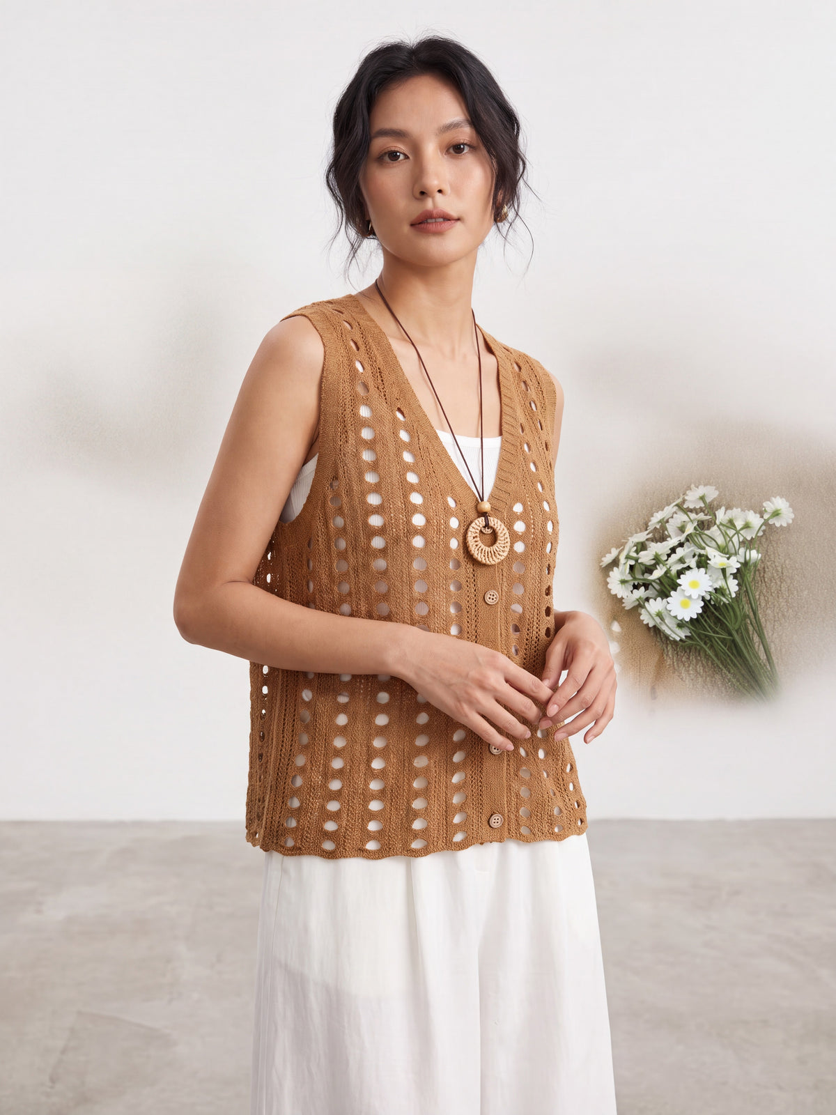 Four knitted hollow-out vests styled over basic white and brown tank tops