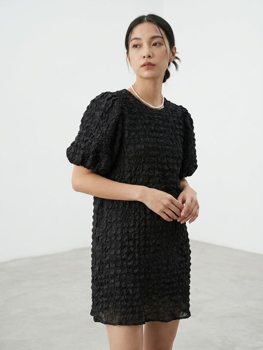 Woman wearing a black textured short-sleeved dress