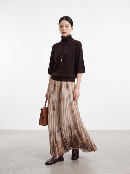 Model showcasing the artistic tie-dye pleated skirt with a dark brown top