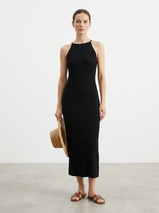 Woman wearing a black sleeveless maxi dress standing outdoors