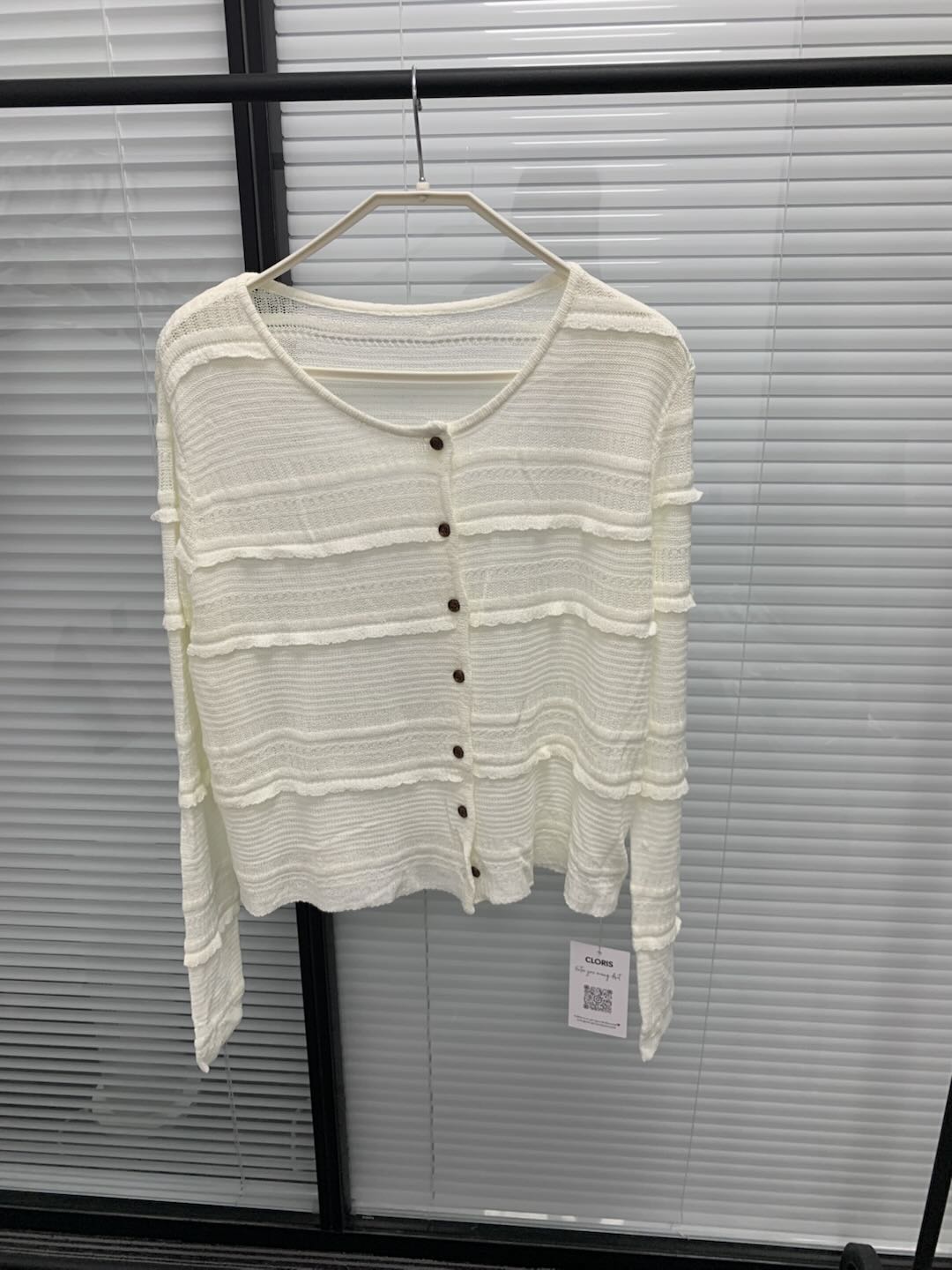 White round neck ruffled textured knit cardigan on a hanger