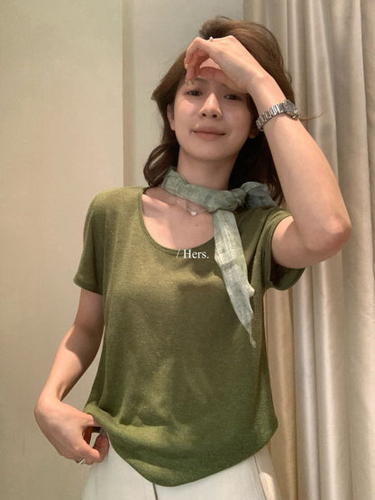 Woman wearing an olive green round neck short sleeve linen knit shirt