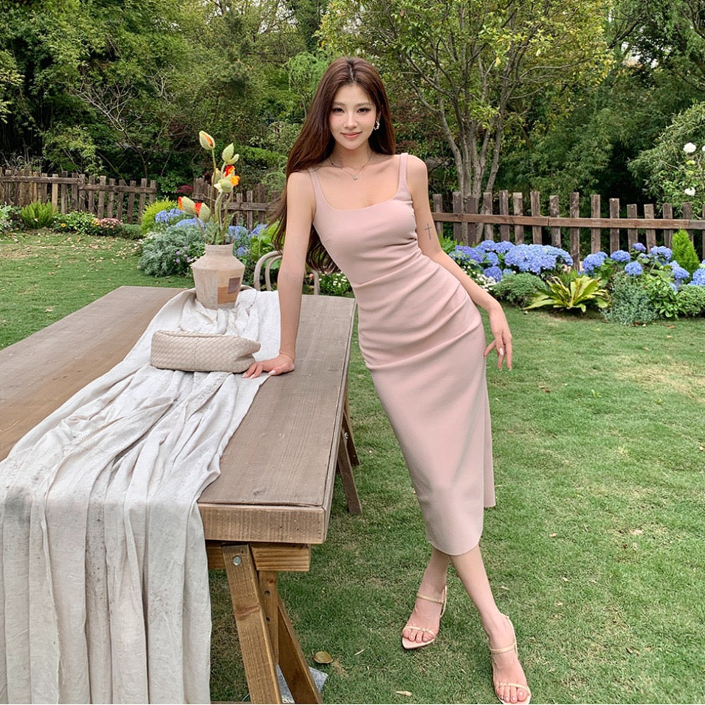 Woman modeling a light pink sleeveless midi dress outdoors