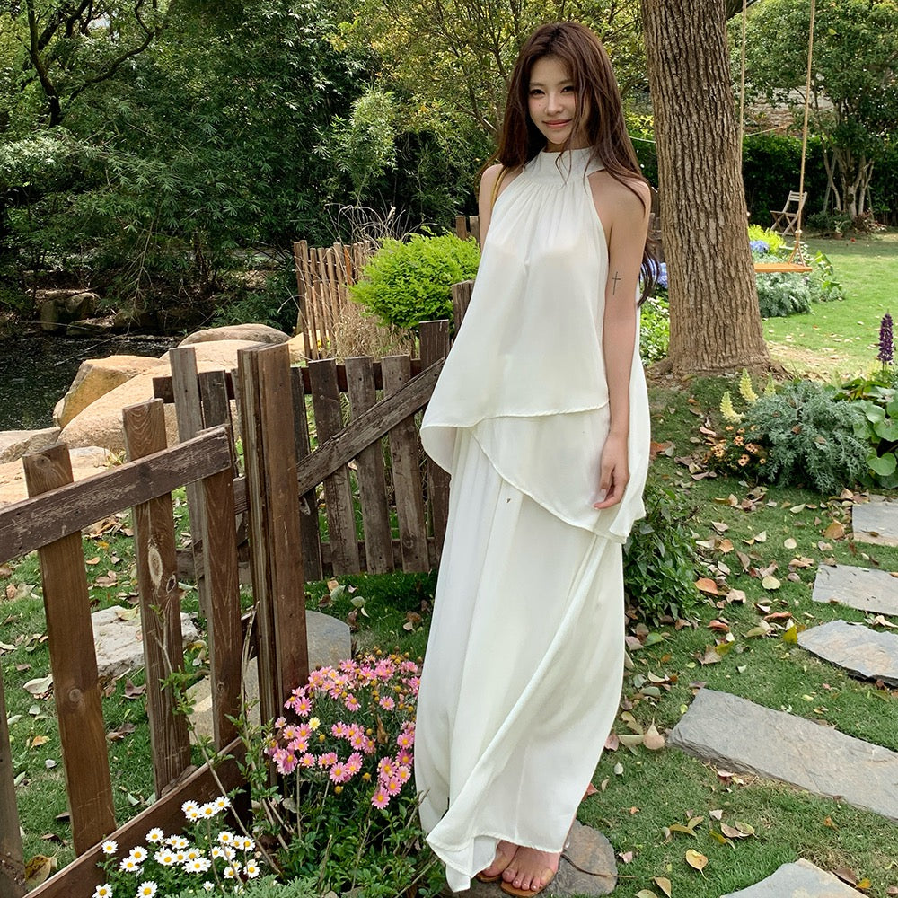 Woman modeling a flowy white two-piece chiffon summer outfit in a garden