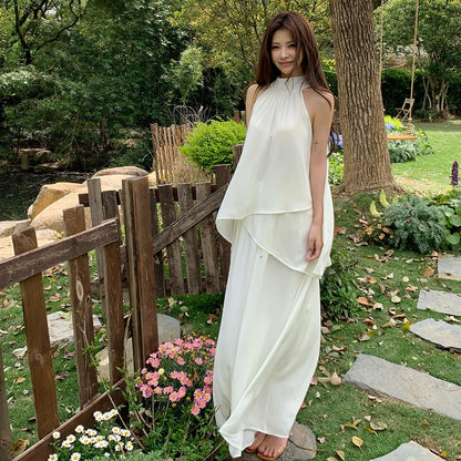 Woman modeling a flowy white two-piece chiffon summer outfit in a garden