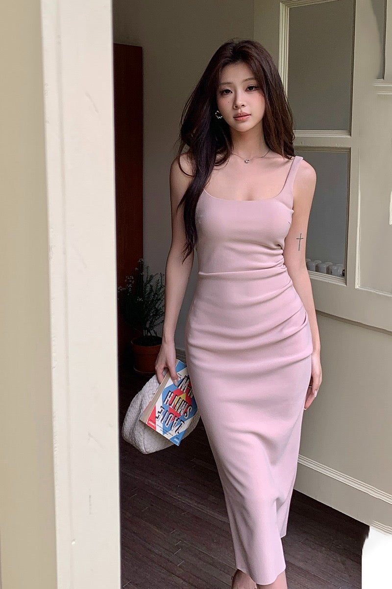Woman wearing a light pink ruched slim fit camisole midi dress