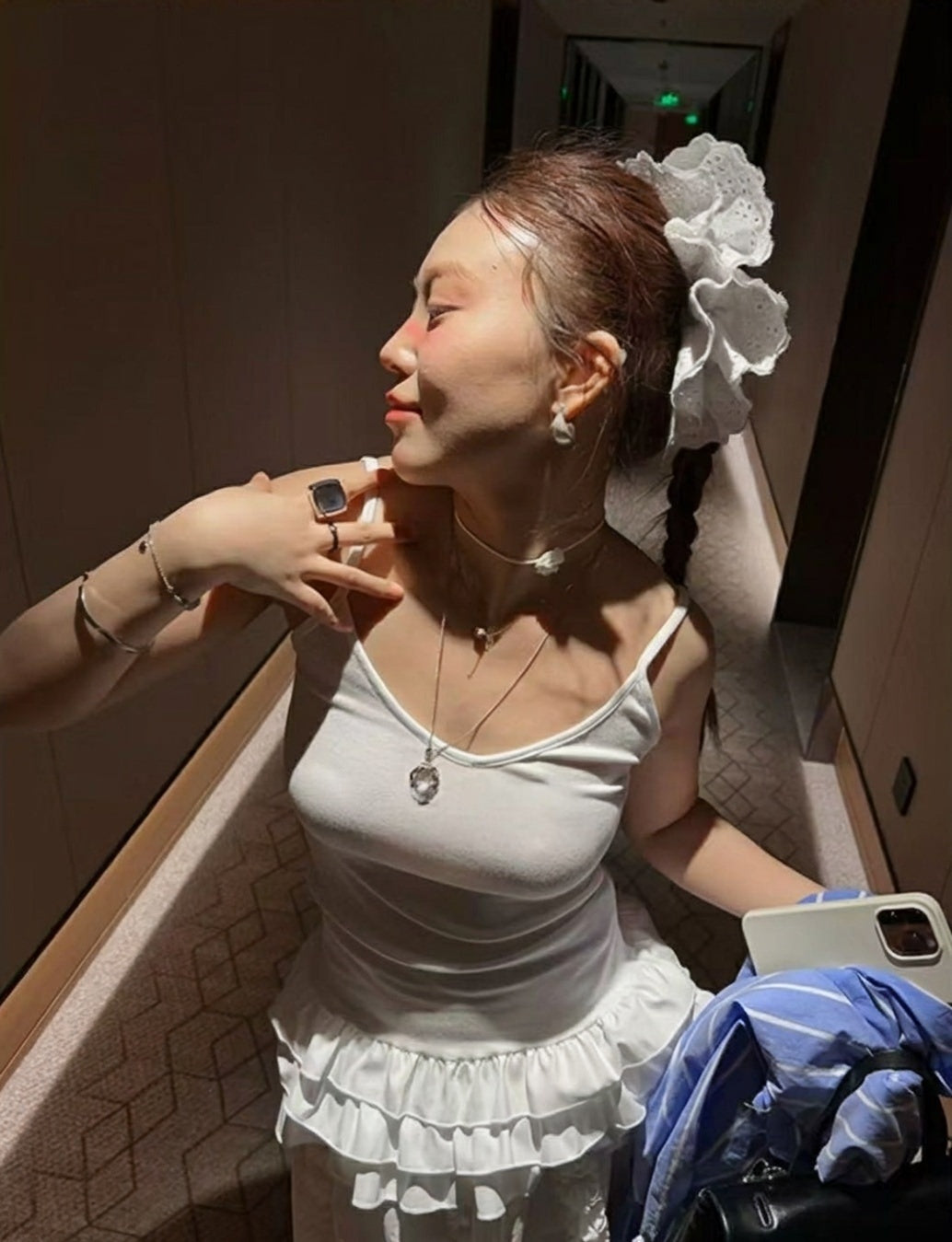 Woman wearing a white ruffled hem camisole top