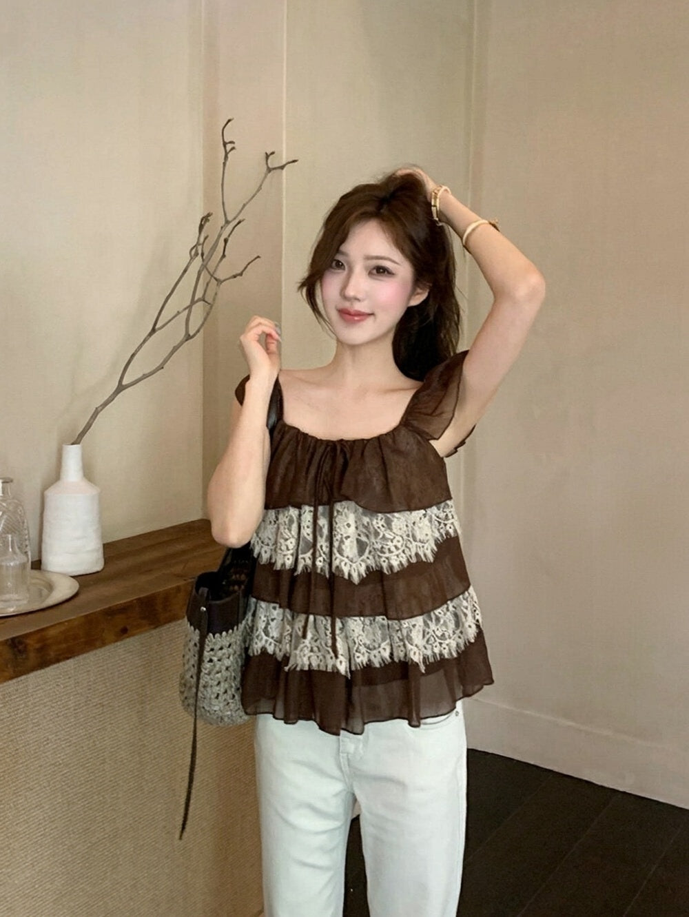 Woman wearing a brown lace spliced tiered ruffle top
