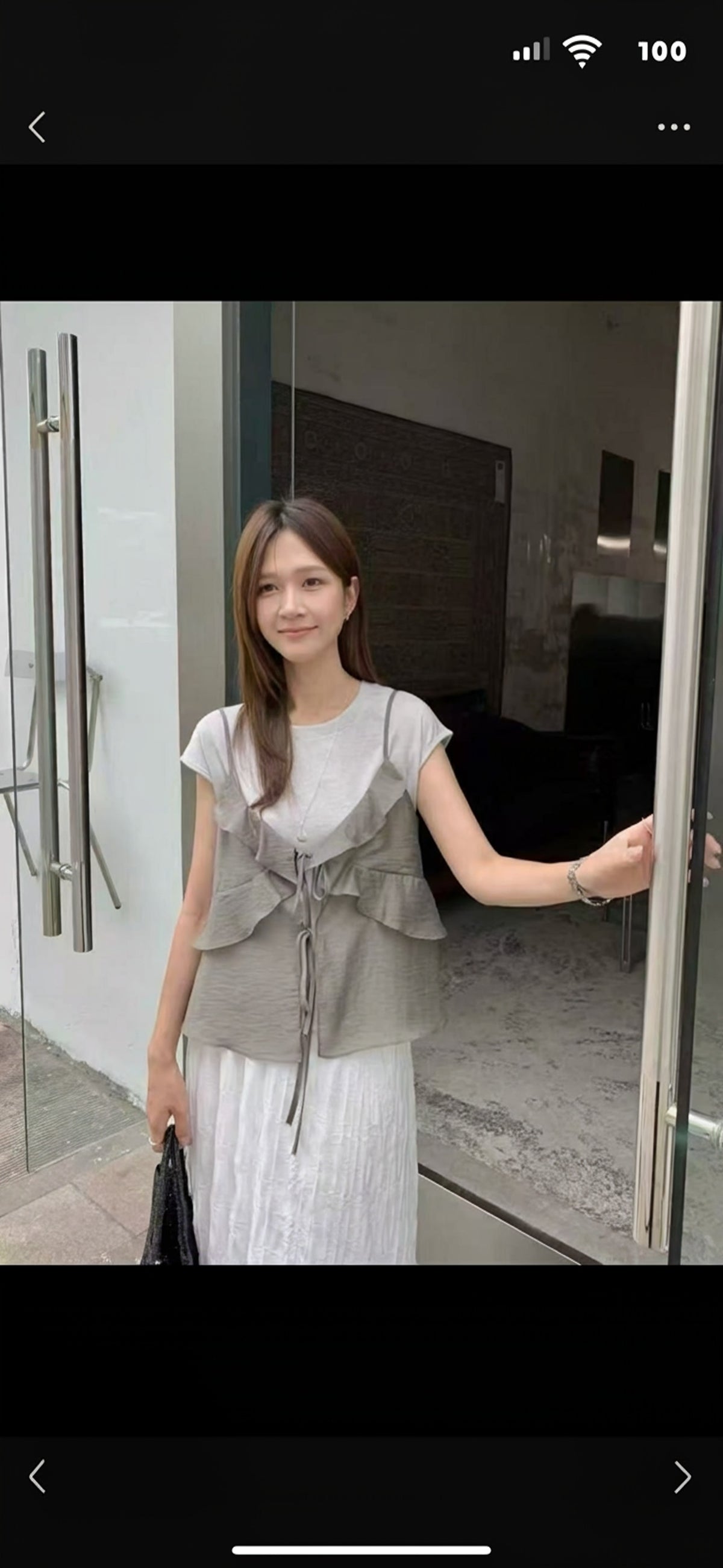 Model wearing a grey ruffled tie-front sheer camisole over a t-shirt