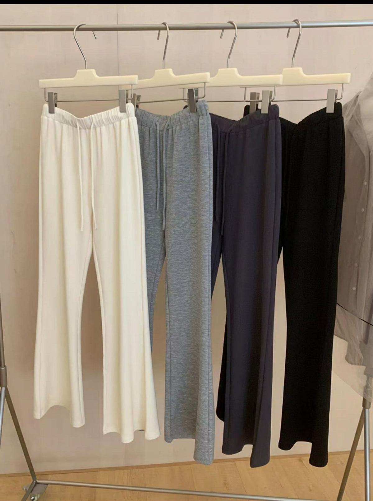 Four colors of Tencel Modal flared pants hanging on a clothing rack