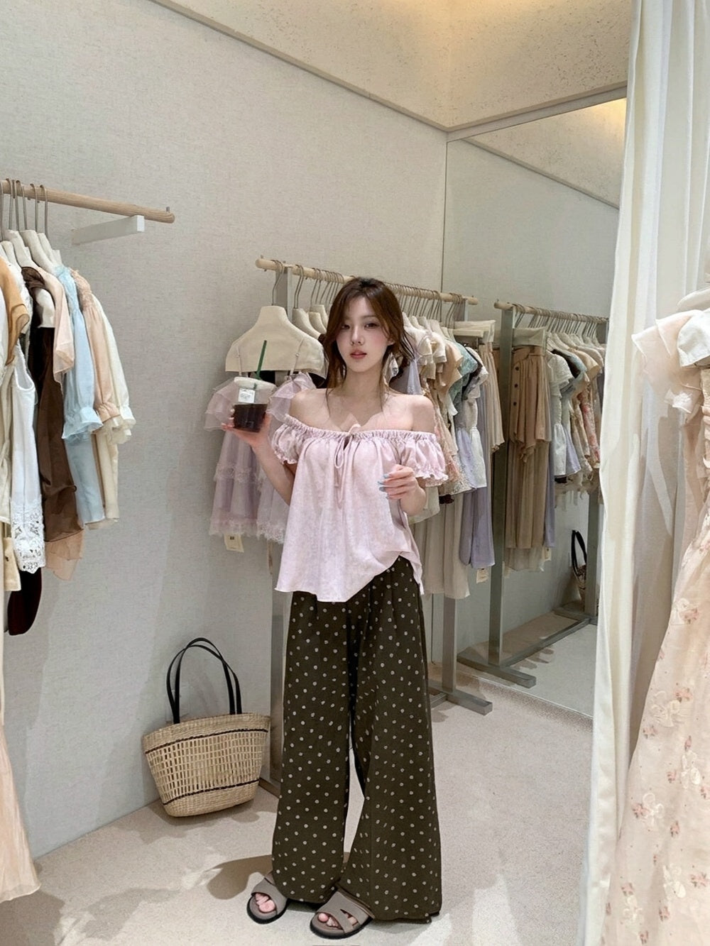 Woman wearing a pink off-the-shoulder gathered top and polka dot pants
