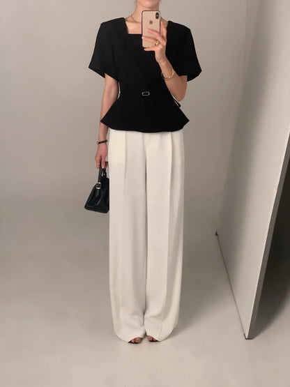 Woman wearing a black square neck short-sleeve peplum top full body shot