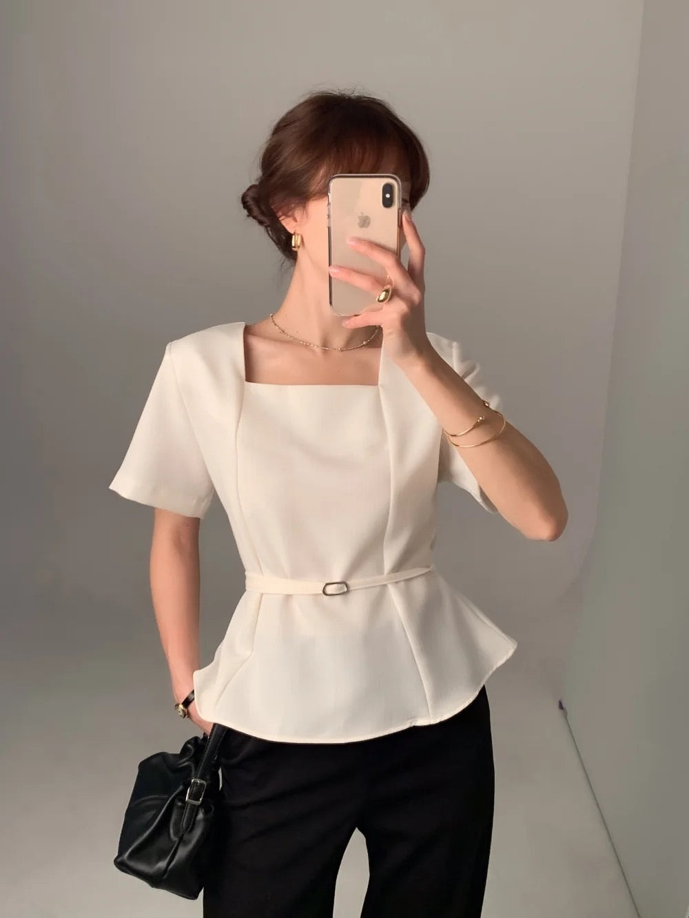 Woman wearing a white square neck short-sleeve peplum top mirror selfie
