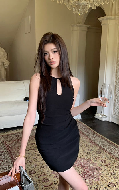 Model wearing a black keyhole sleeveless mini dress holding a wine glass