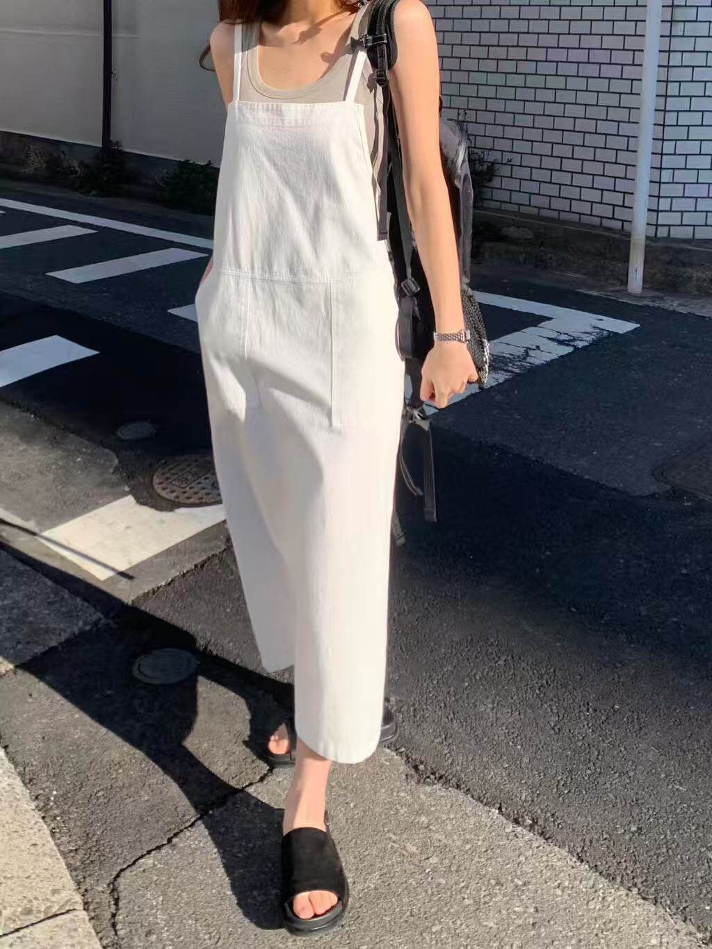 Model wearing a white overall dress outdoors
