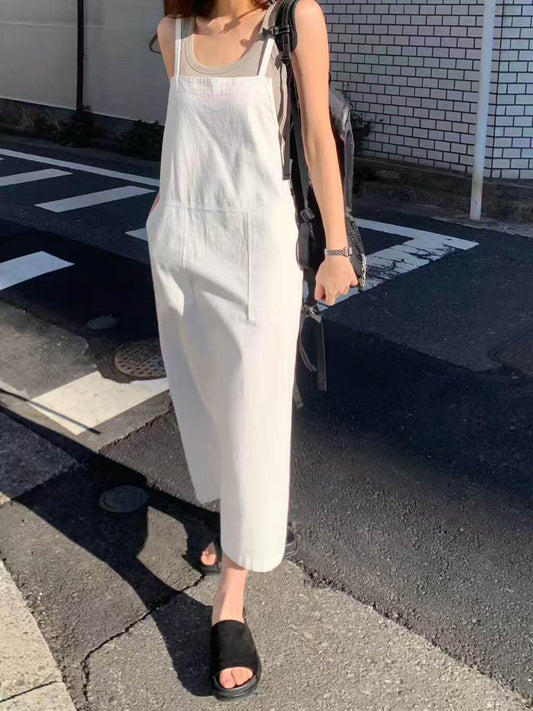 Model wearing a white overall dress outdoors