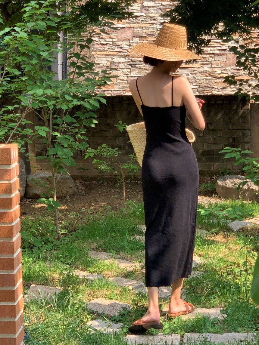 Back view of a black maxi dress in a garden setting