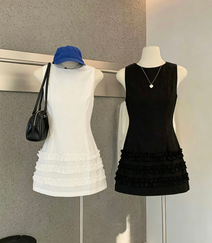 Mannequins displaying white and black sleeveless ruffle hem mini dresses