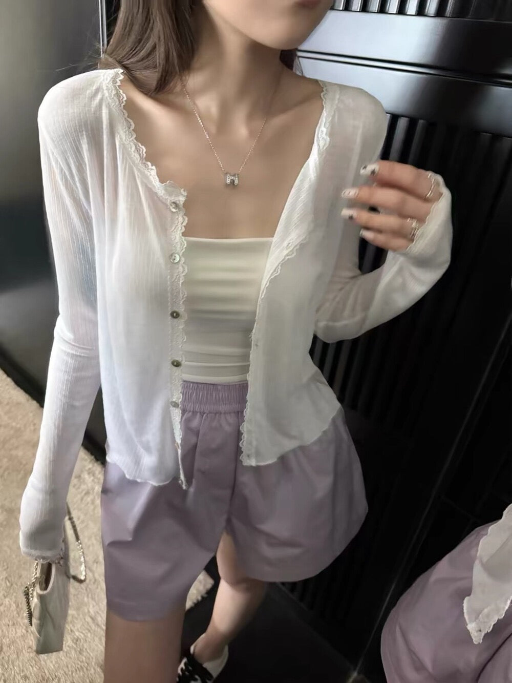 Model wearing white lace spliced soft sunscreen cardigan with shorts