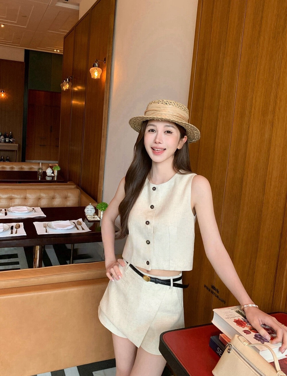 Close-up of woman in beige sleeveless button-up top and skort