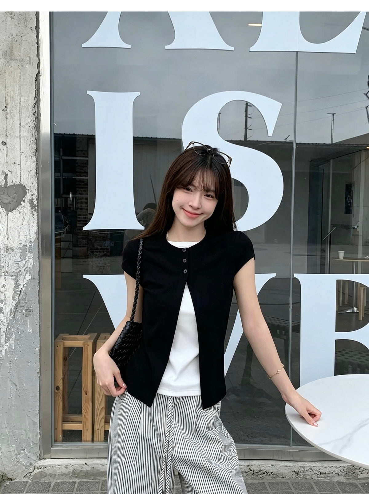 Model wearing a black faux two-piece short sleeve shirt smiling