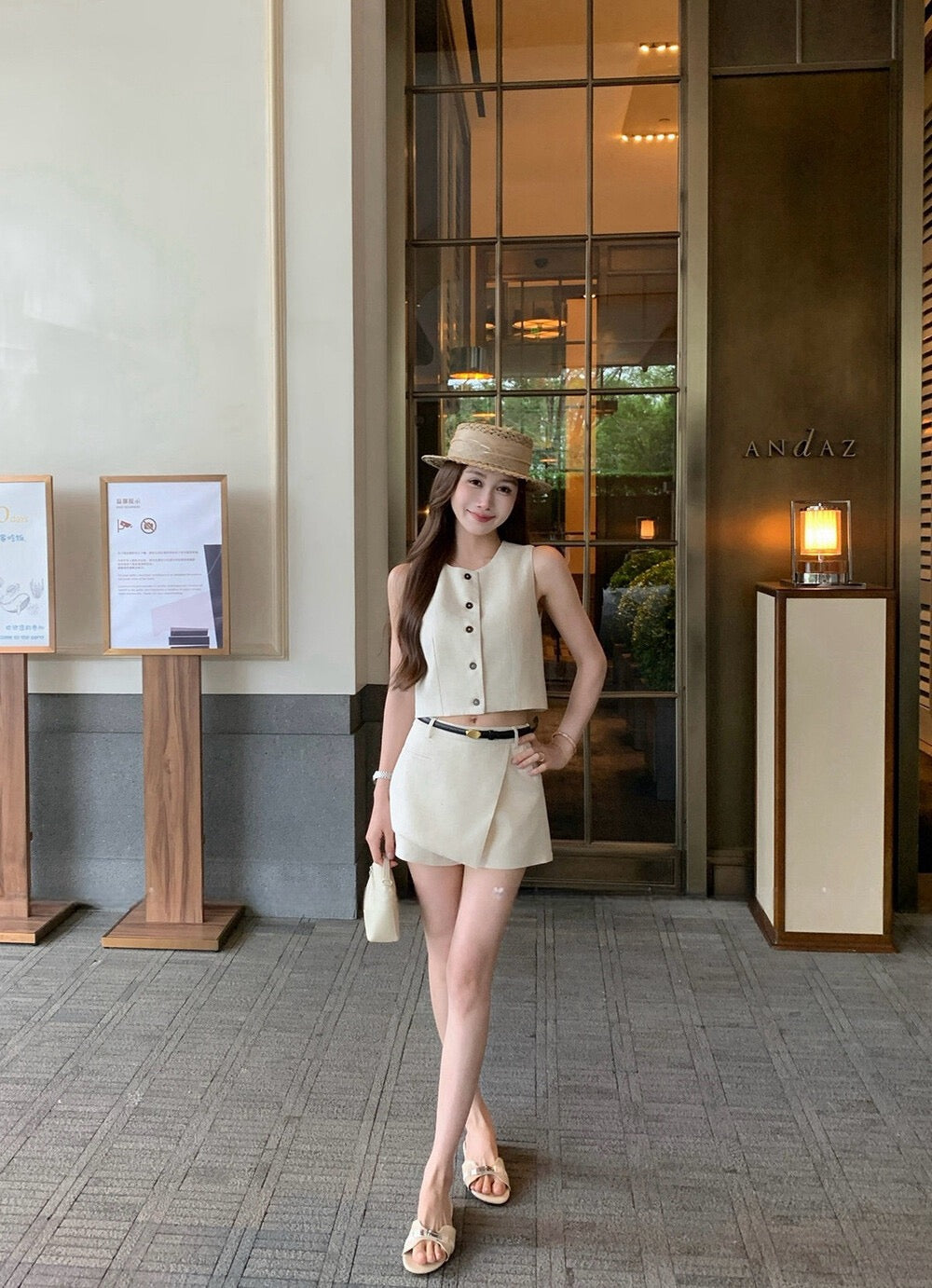 Woman modeling beige vest and irregular skort set outside