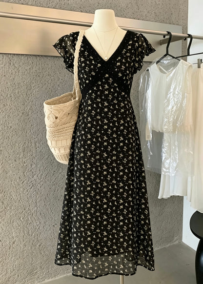 Black floral dress displayed on a mannequin with a woven tote bag