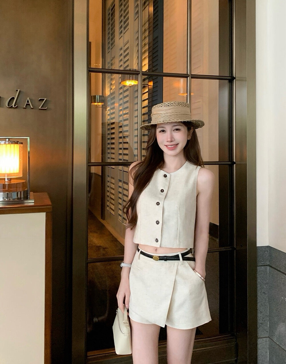 Half body shot of woman in beige vest and skort set
