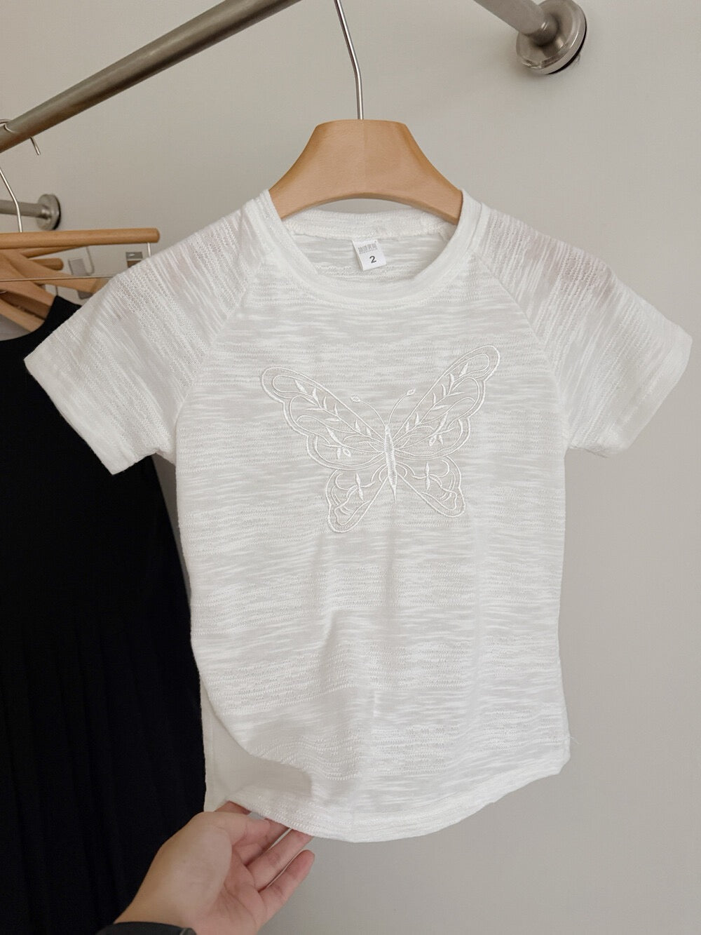 White butterfly embroidered t-shirt on hanger