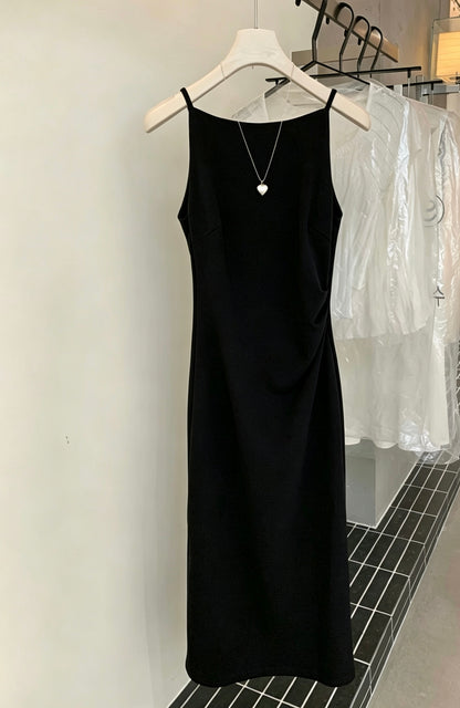 Black sleeveless dress hanging on a hanger