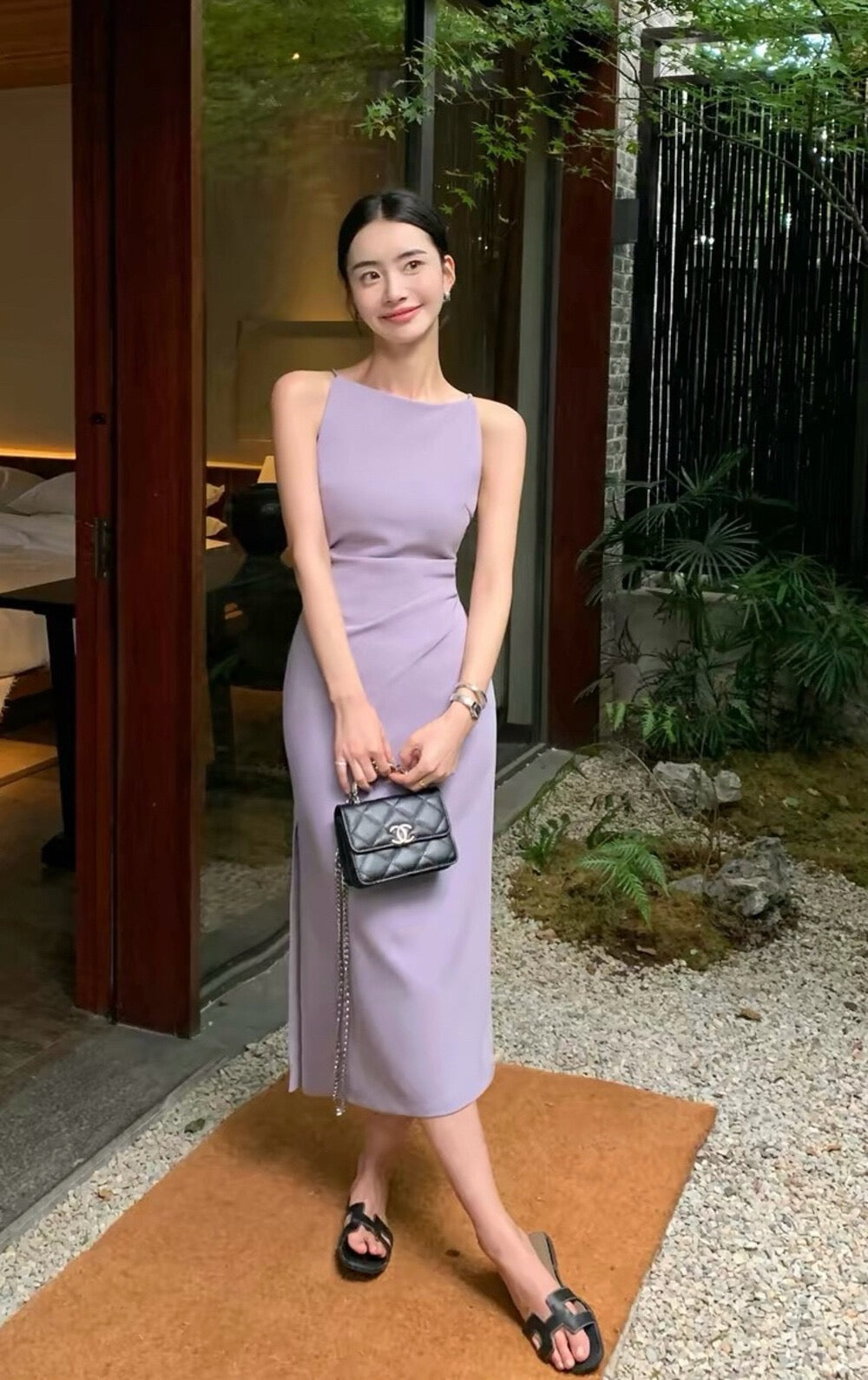 Woman modeling a light purple sleeveless midi dress with side slit