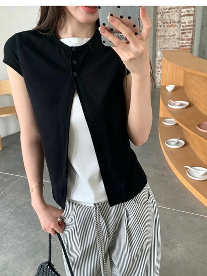 Mirror selfie of a woman wearing a black faux two-piece short sleeve shirt