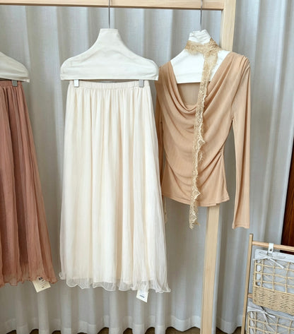 Apricot mesh skirt paired with a beige long-sleeve top on a rack