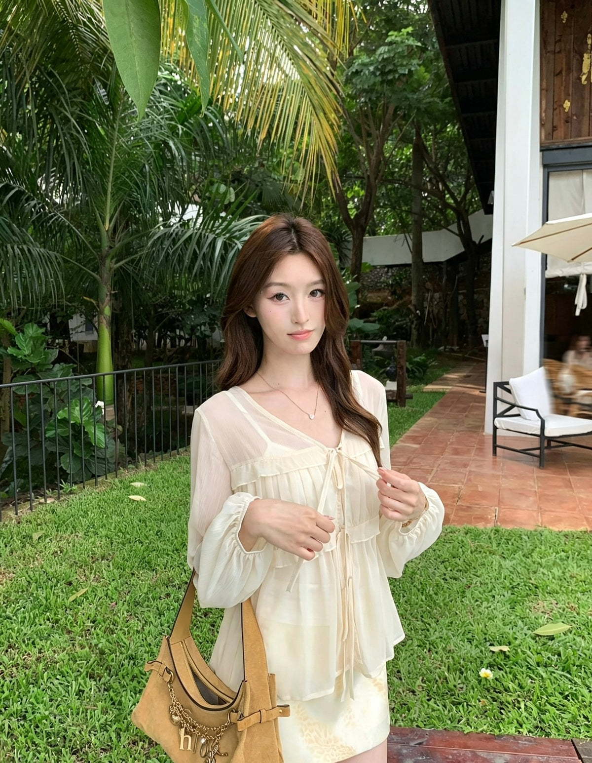 模特兒穿著杏色韓系燈籠袖小荷葉邊褶皺V領小衫吊帶背心兩件套
