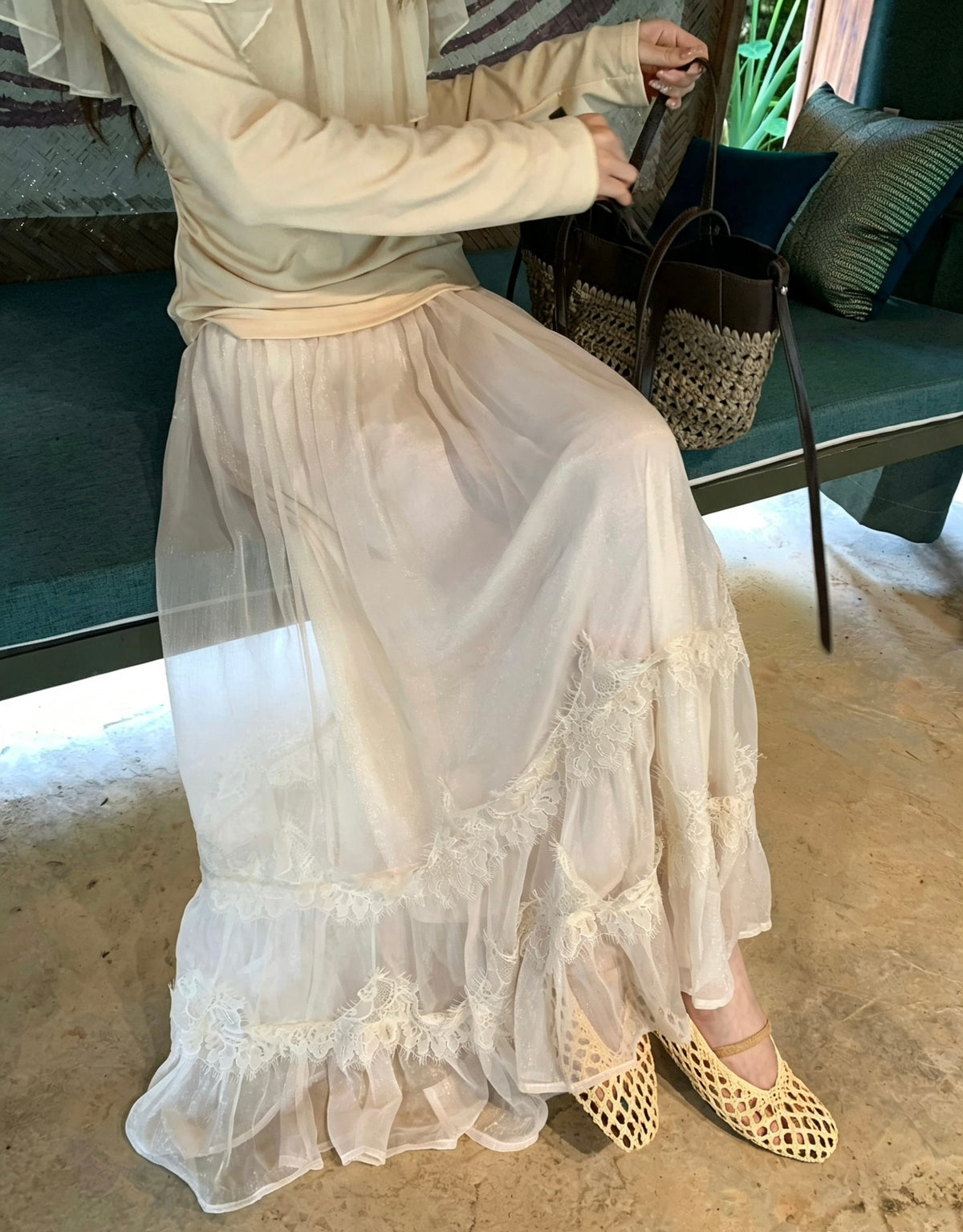 Model sitting wearing apricot layered tulle skirt