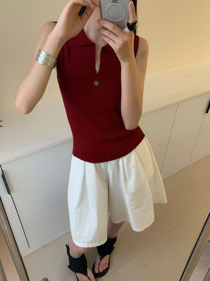 Model wearing retro red ribbed sleeveless polo top taking mirror selfie