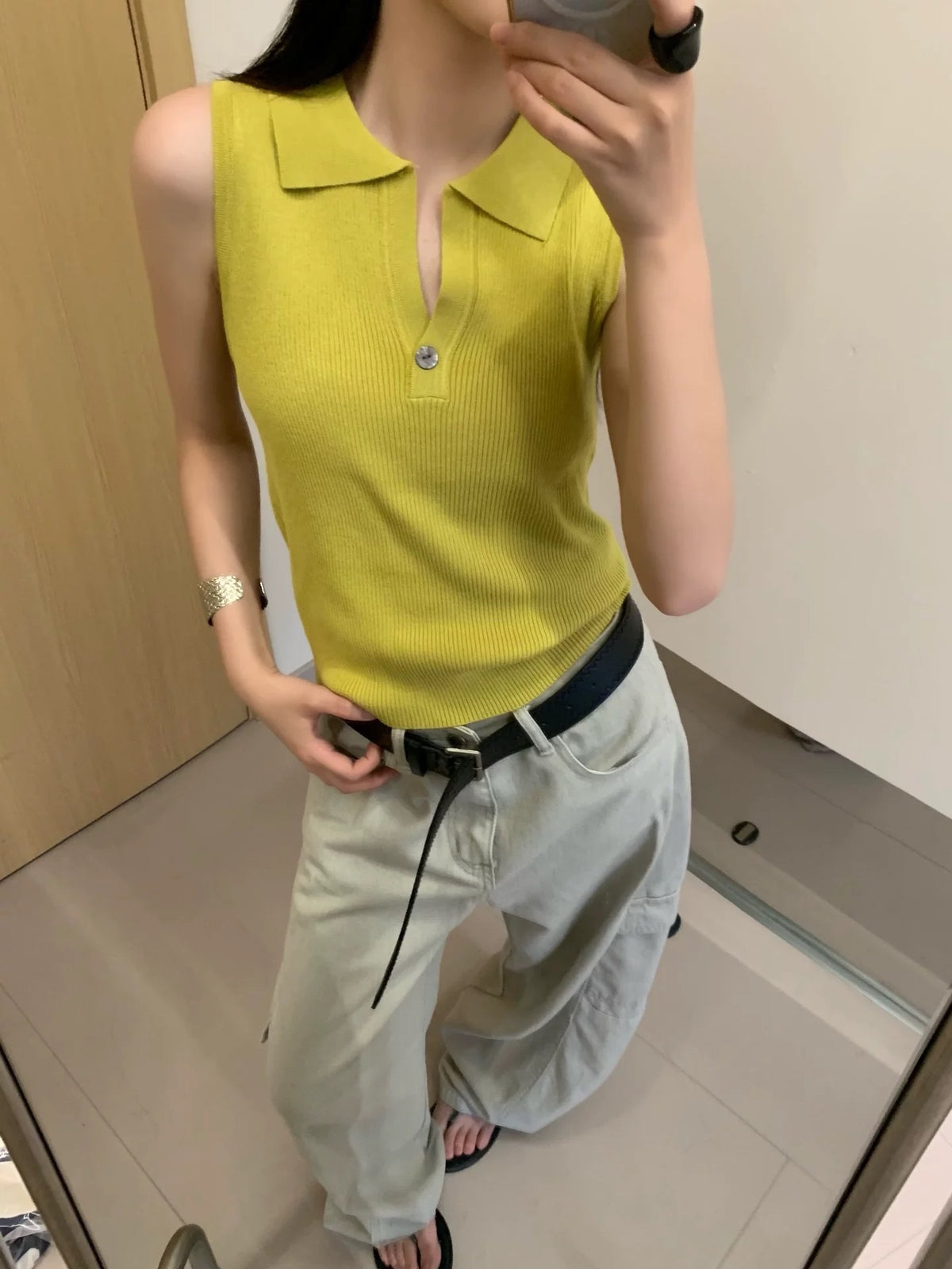 Model wearing mustard yellow ribbed sleeveless polo top