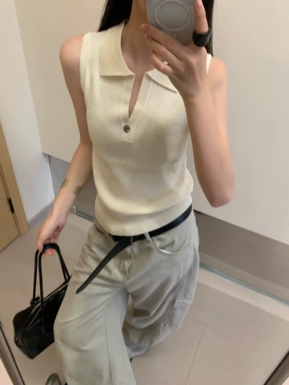 Model wearing apricot ribbed sleeveless polo top taking mirror selfie