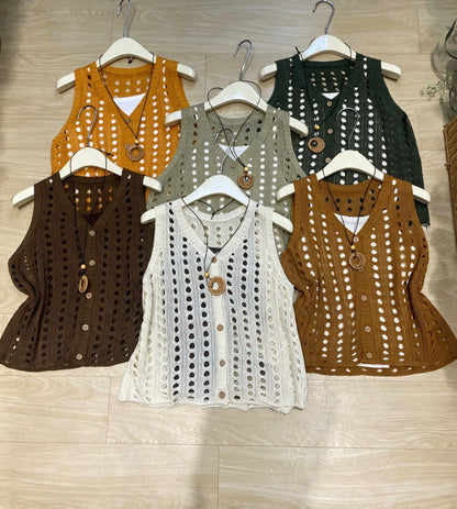 Six knitted hollow-out vests in various colors arranged on hangers on a wooden floor