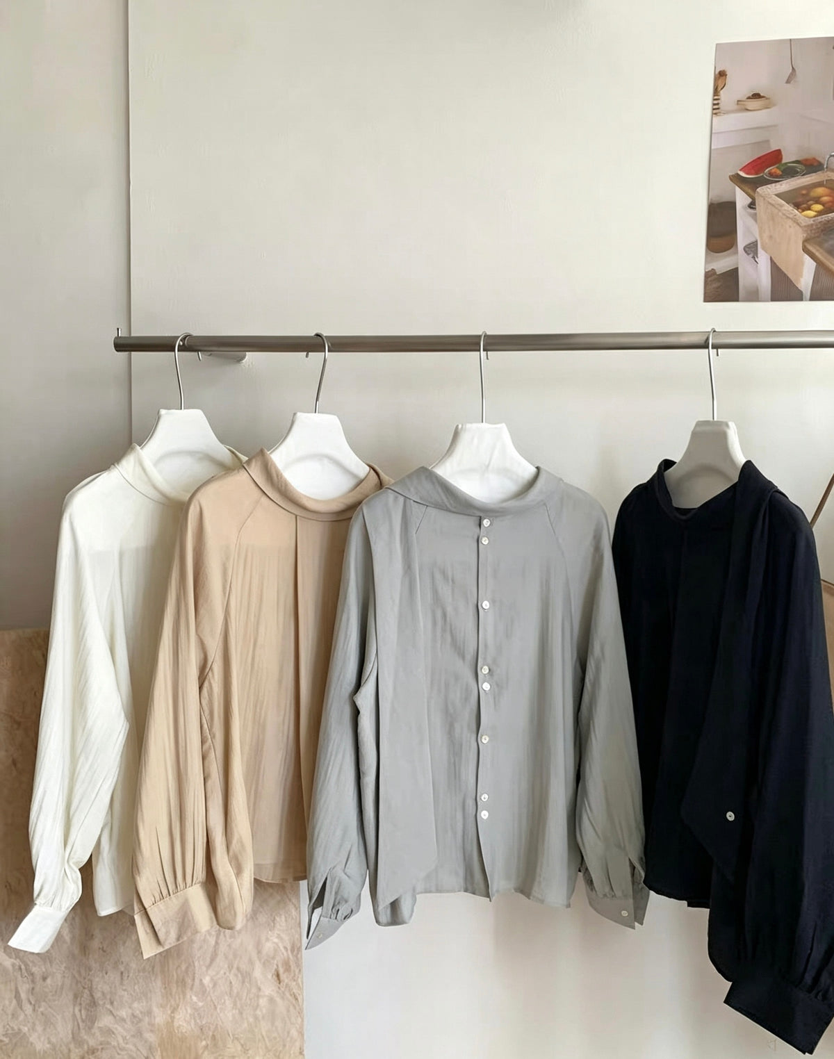 Close-up of four two-way tie blouses hanging on a rack.