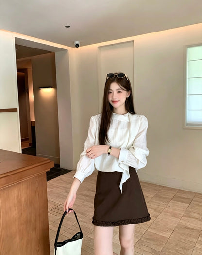 Model wearing a white French design shoulder button tie blouse