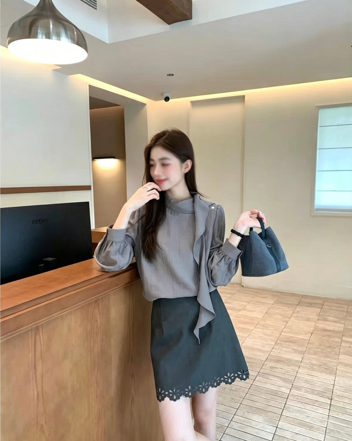 Model wearing a grey French design shoulder button tie blouse